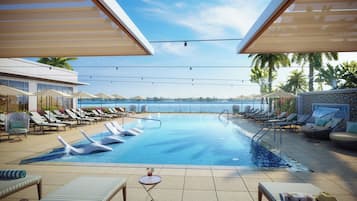 Una piscina al aire libre, camas de piscina con cargo, sombrillas