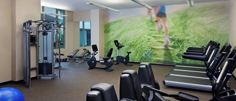 Ein Fitnessstudio mit Laufbändern, Übungsbällen und Kraftgeräten.