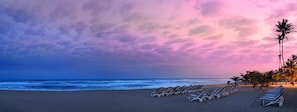 Vlak bij het strand, wit zand, ligstoelen aan het strand, parasols