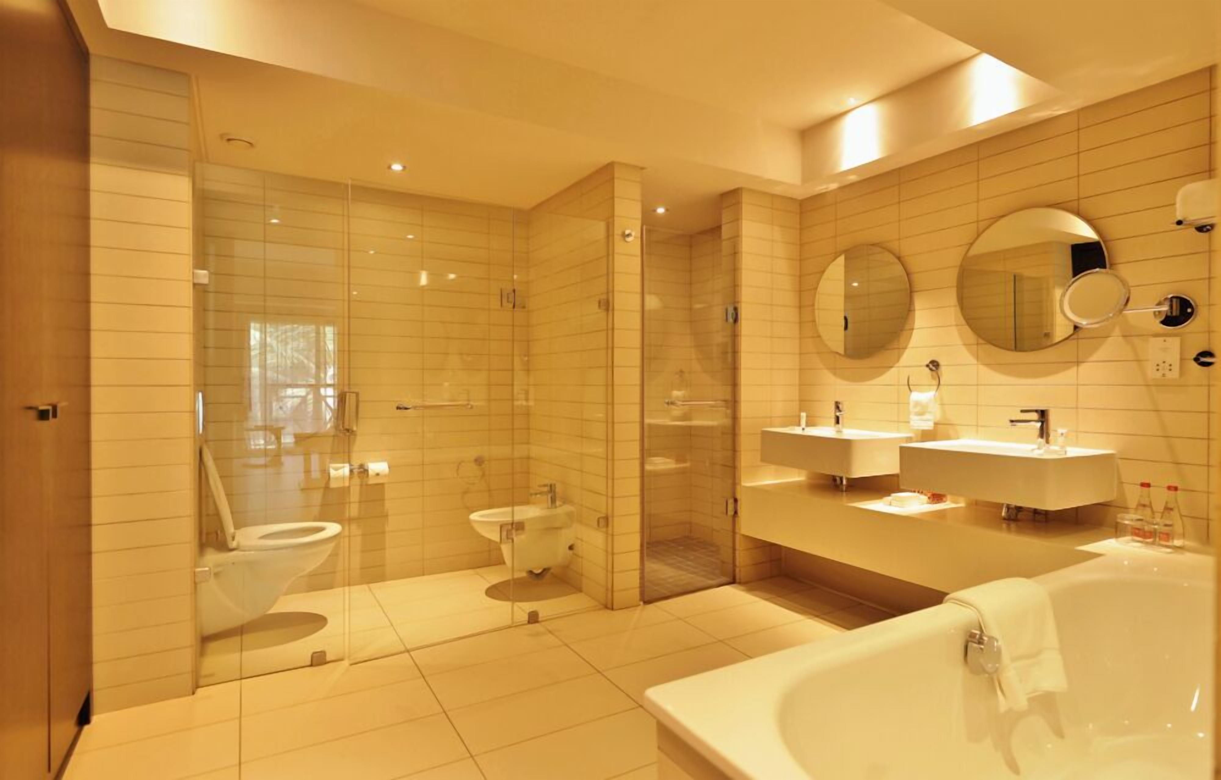 Un bagno moderno con doccia a vetro, un water, un bidet e una grande vasca da bagno.