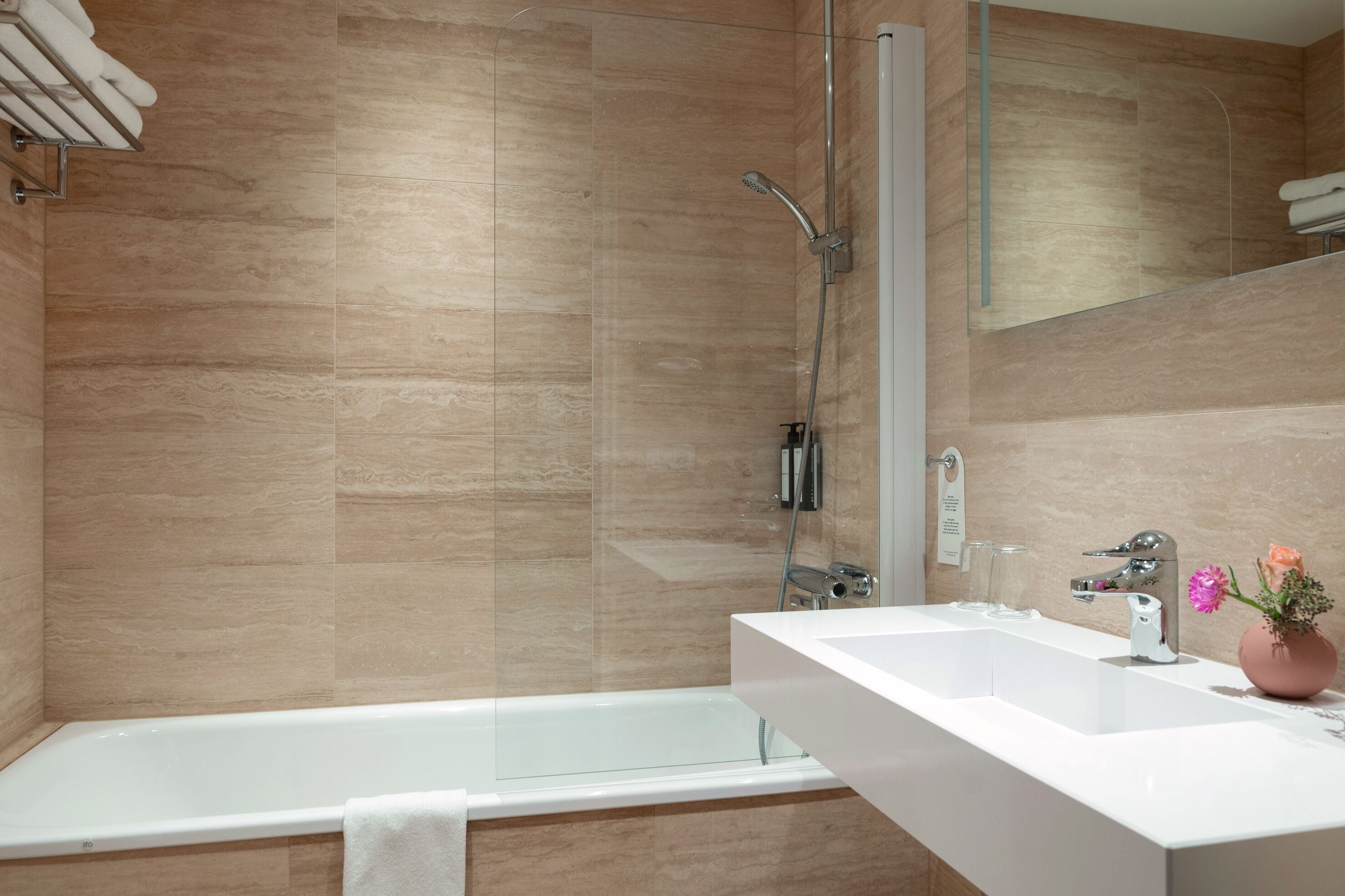 A modern bathroom with a bathtub, a glass-enclosed shower, and a white vanity with a mirror.