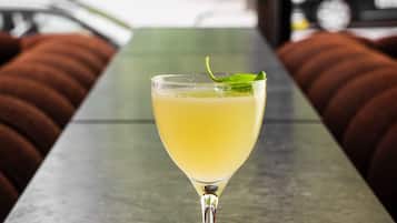 Un bicchiere da martini con una fetta di lime su un tavolo in metallo in un'area salotto all'aperto.