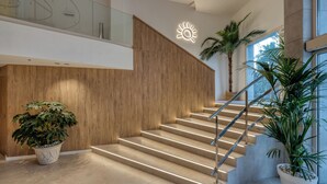 Un intérieur moderne avec un mur en bois, un escalier doté de rampes en métal et des plantes en pot.