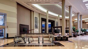 A spacious lobby with a glass railing, escalators, and a reception desk labeled "STATEHOUSE CONVENTION CENTER". - Little Rock Marriott (Little Rock)