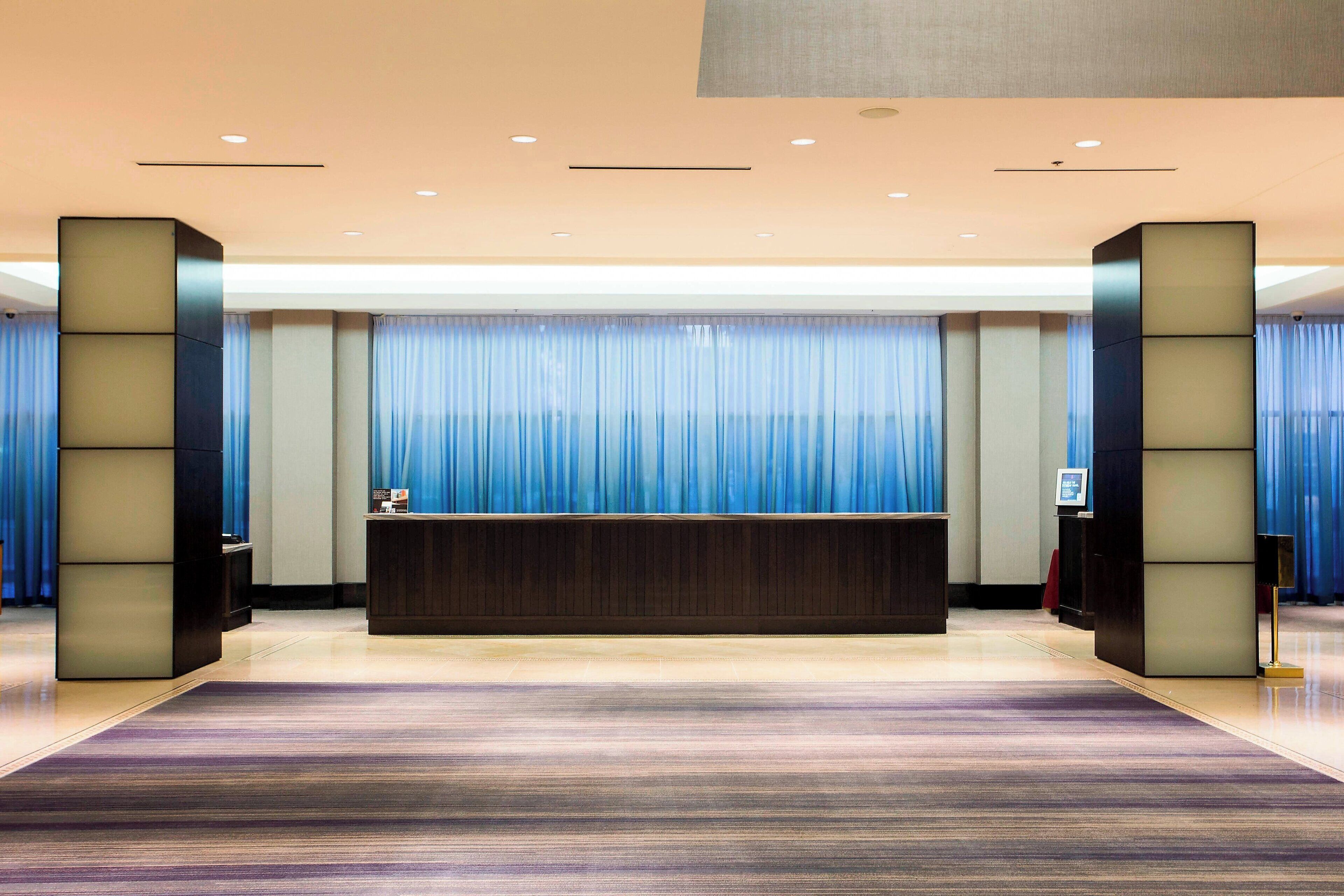 A reception area with a reception desk, blue curtains, and a modern design.
