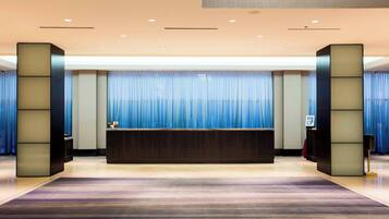 A reception area with a reception desk, blue curtains, and a modern design.