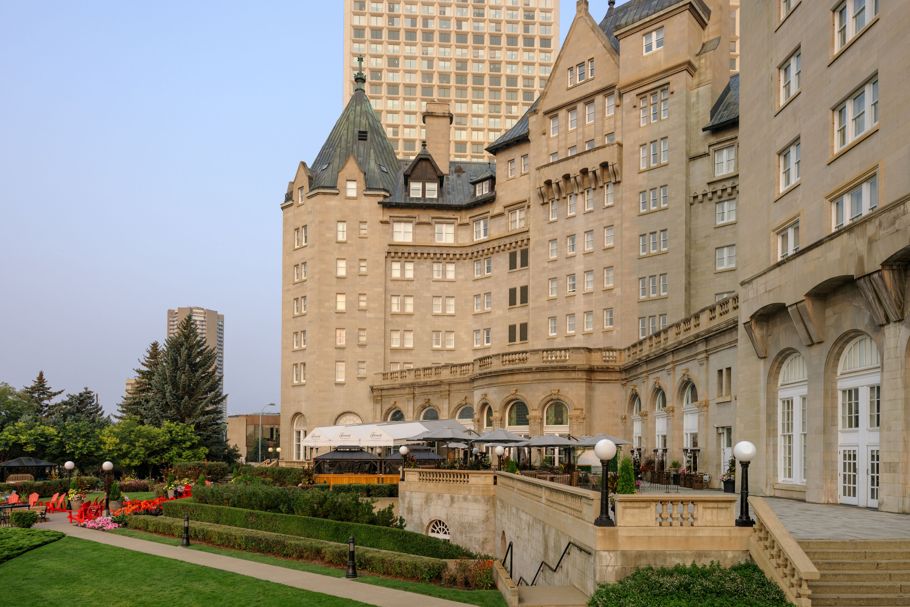 A historic building with multiple floors, large windows, and a central courtyard with seating areas and greenery.