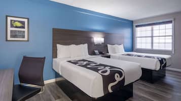 Una habitación de hotel con dos camas, un escritorio y una silla.