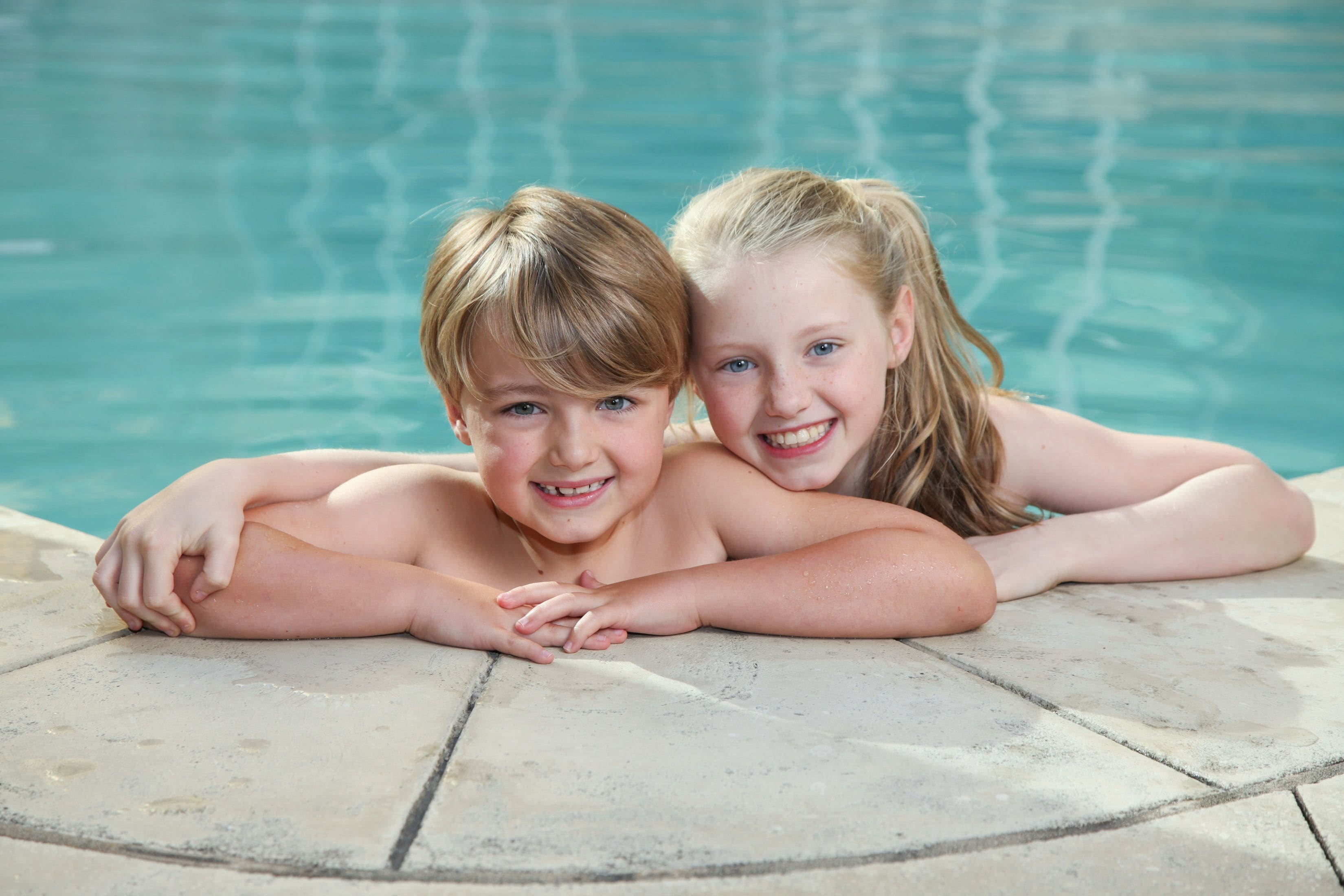 Twee kinderen ontspannen aan het zwembad.