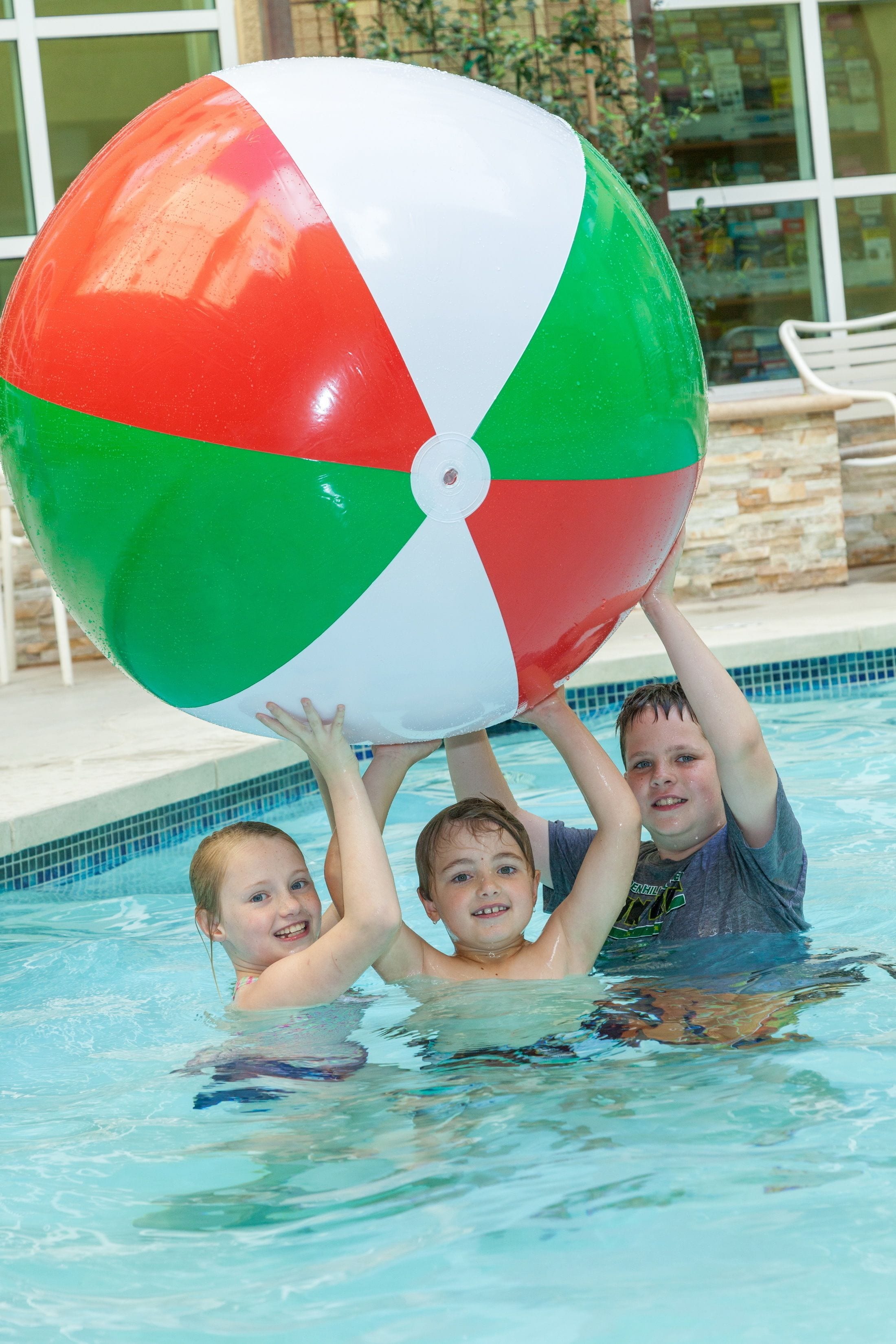 A swimming pool with a large beach ball.