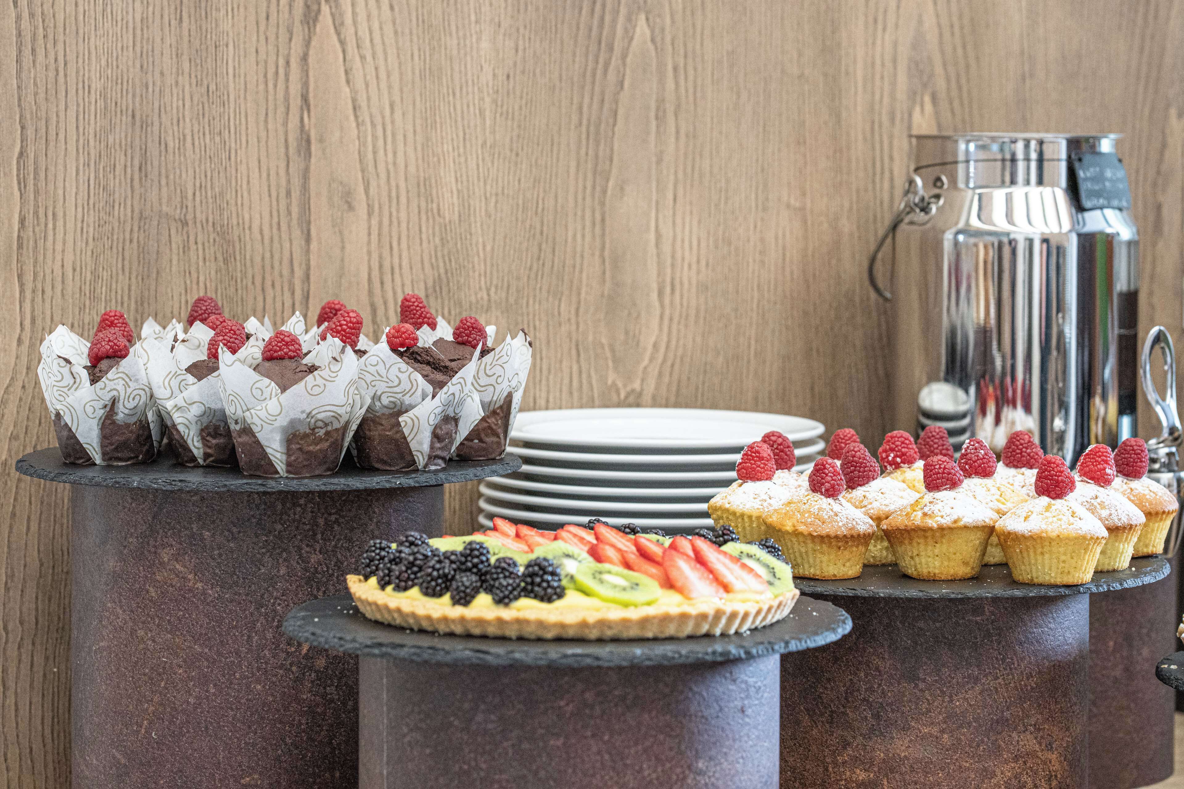 A dessert display with various pastries and a fruit tart.