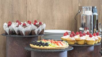 A dessert display with various pastries and a fruit tart.