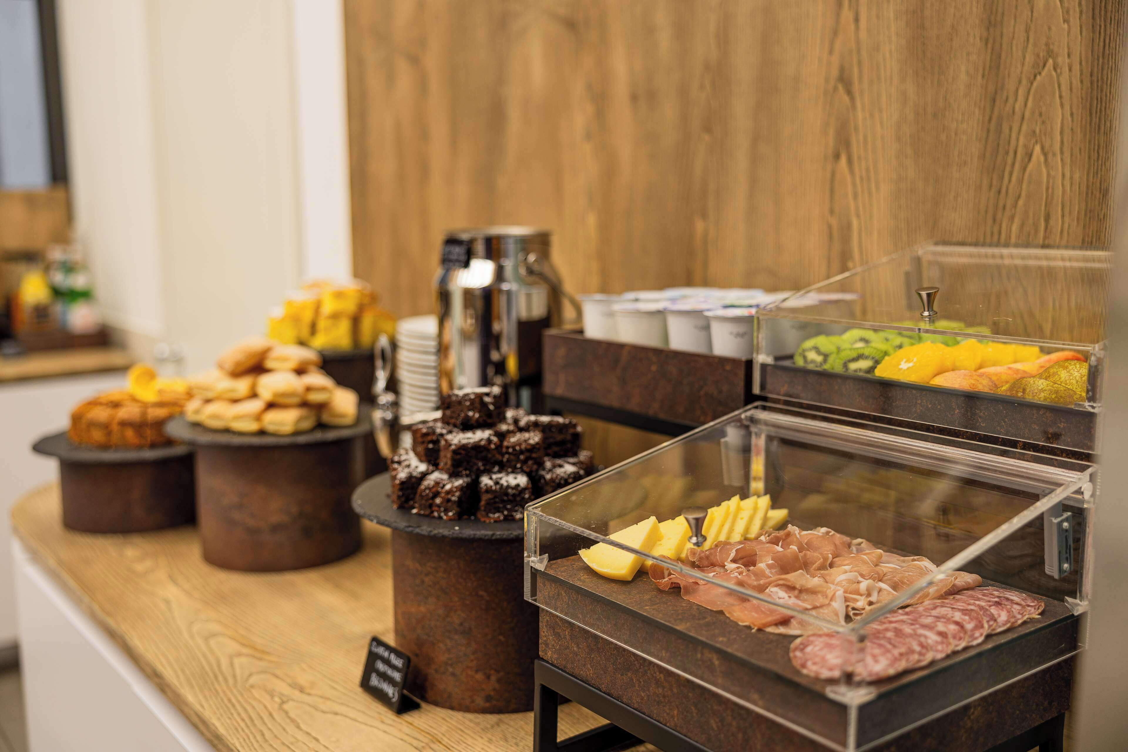 Buffet amb diferents plats, incloent pastissos, carns i fruites.