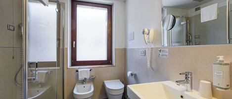 Un baño con ducha, bidé, inodoro y lavabo.