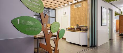 Un interior moderno con techo de madera, un panel informativo colgado en la pared y un mostrador con productos alimenticios.