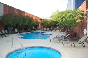 Relax by the pool surrounded by lounge chairs and trees.