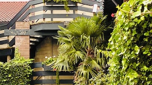 A building with a tower featuring the word "Inn" on its facade, surrounded by greenery and a brick structure. - Coachman Inn & Suites (Oak Harbor)