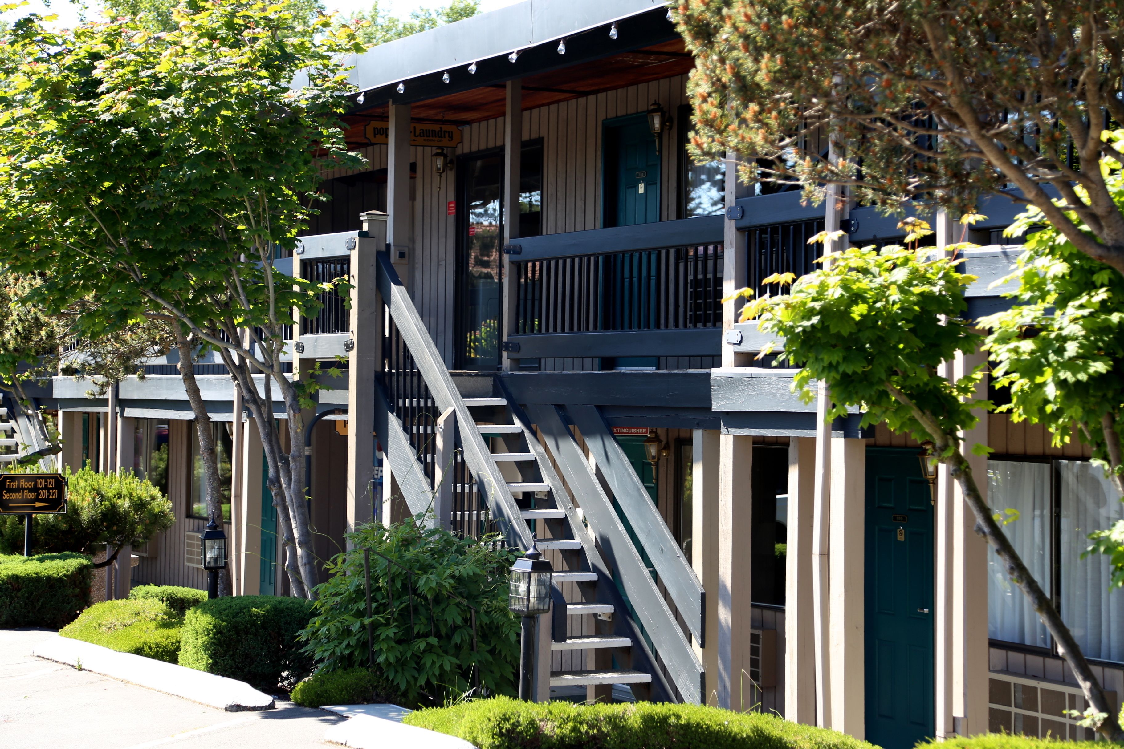 A multi-story building with a wooden staircase leading to a balcony.