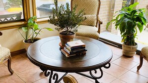 A cozy reading nook with a round table, a chair, and a potted plant. - Coachman Inn & Suites (Oak Harbor)
