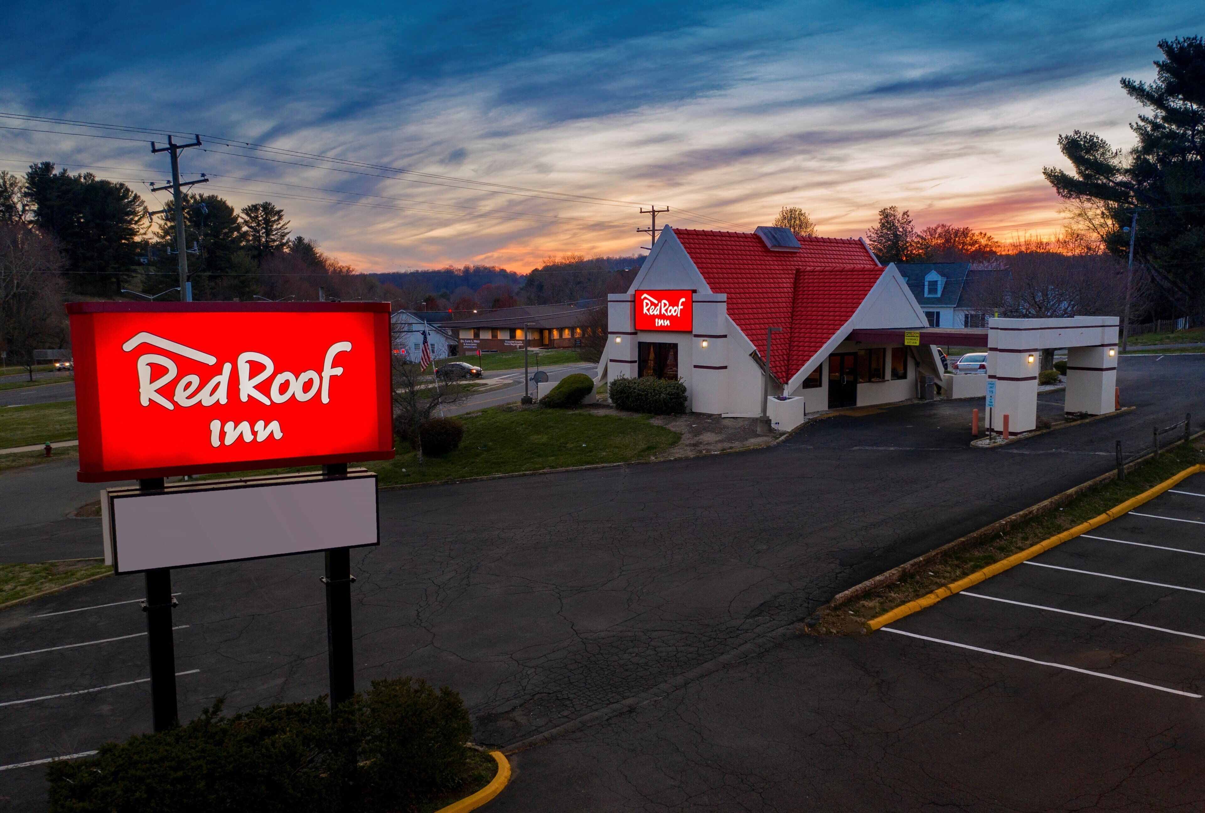 Un Red Roof Inn con tejado rojo y un letrero.