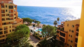 A coastal hotel with multiple balconies, a swimming pool, and a view of the sea. - Columbus Hotel Monte-Carlo, Curio Collection by Hilton (Monaco)