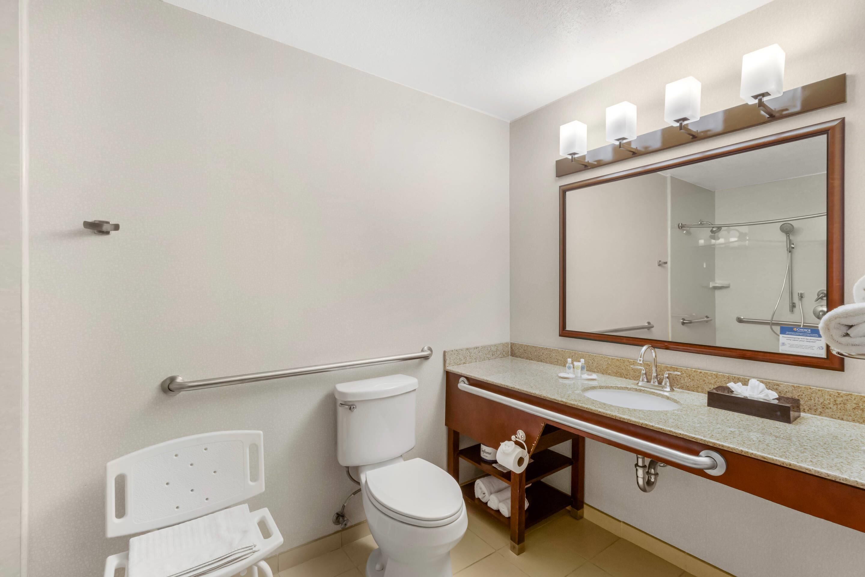 A modern bathroom with a toilet, sink, and mirror.