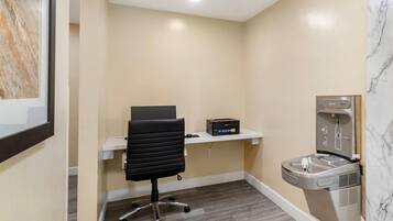 A small office space with a desk, chair, and a water dispenser.