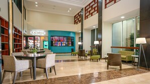 En rummelig lobby med et casino-skilt, behagelige siddepladser og et stort vindue.