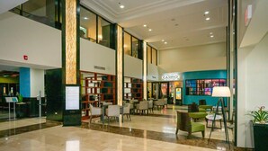 A spacious lobby with a casino, seating areas, and a reception desk.