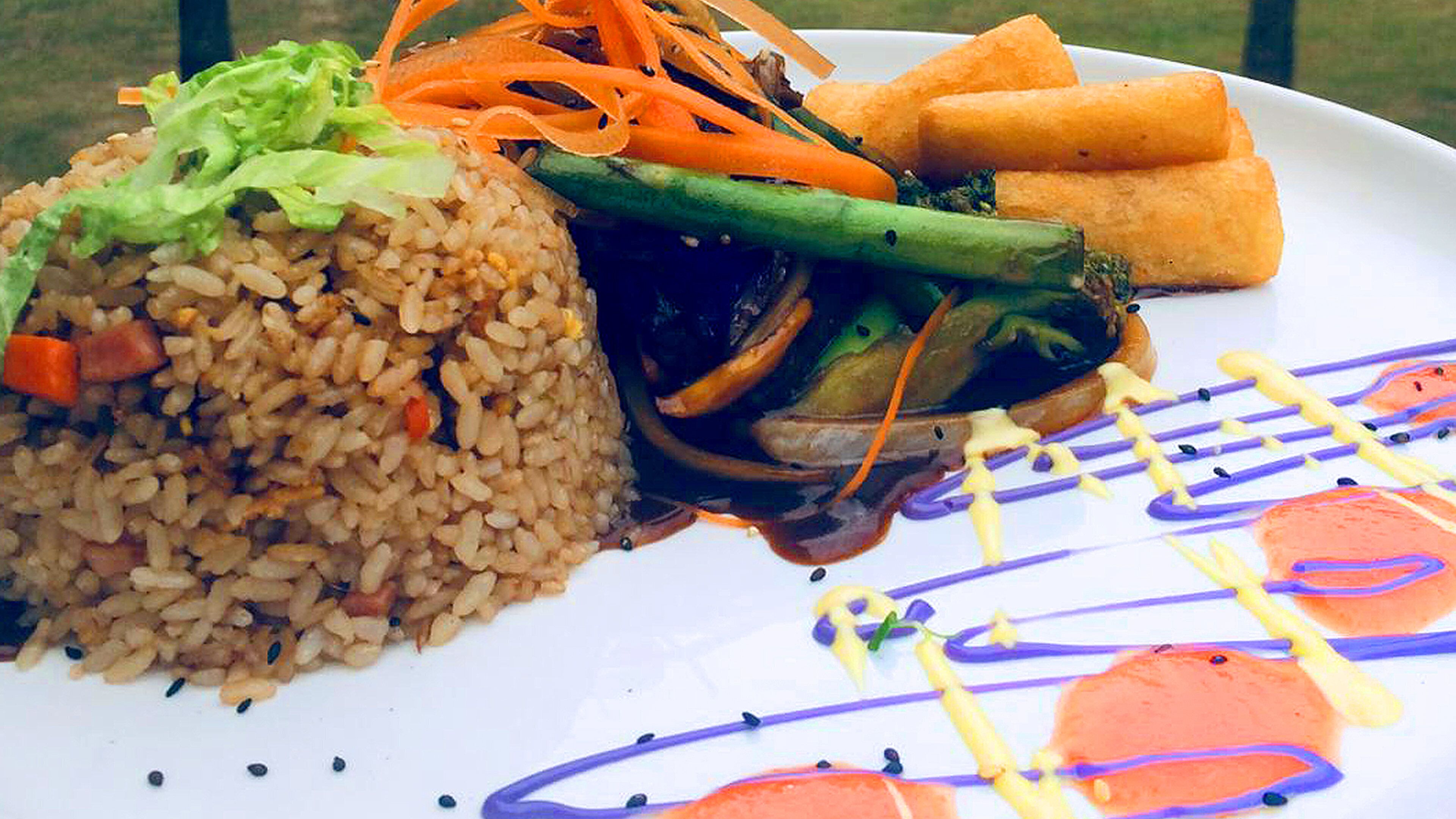 A plate with rice, vegetables, and fried items.