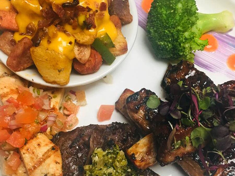 A plate with various food items including steak, potatoes, and vegetables.
