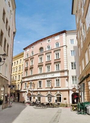 Un hôtel doté d’un café au rez-de-chaussée, avec une terrasse extérieure agrémentée de parasols.