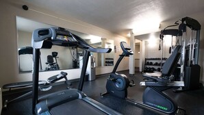 Uma academia com esteiras, elípticos e aparelhos de musculação.