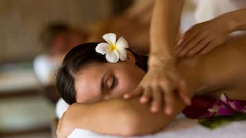 A person receiving a massage with a flower in their hair.