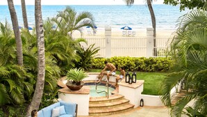 A pool area with a hot tub, a blue sofa, and a view of the beach. - Fairmont El San Juan Hotel (Carolina)