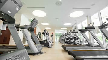 A gym with multiple treadmills, stationary bikes, and elliptical machines.