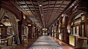 A grand hallway with ornate wood paneling, a patterned carpet, and a pool table. - Fairmont El San Juan Hotel (Carolina)
