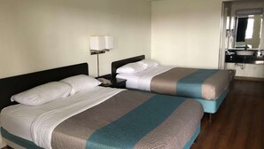 A hotel room with two beds, a nightstand with a lamp, a bathroom with a sink and mirror. - Days Inn by Wyndham Indianapolis South (Indianapolis)