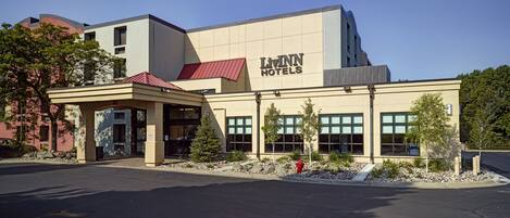A modern hotel with a flat roof, large windows, and a covered entrance.