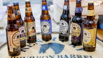 A selection of bourbon barrel beer bottles arranged on a barrel-shaped table.