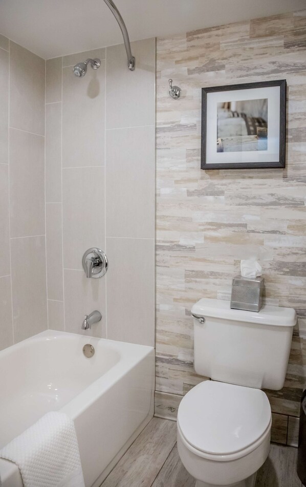 Un baño con bañera, inodoro y ducha.