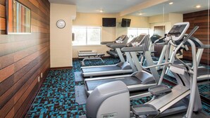 A gym with treadmills, a clock, and a large window. - Fairfield Inn & Suites Cheyenne (Cheyenne)