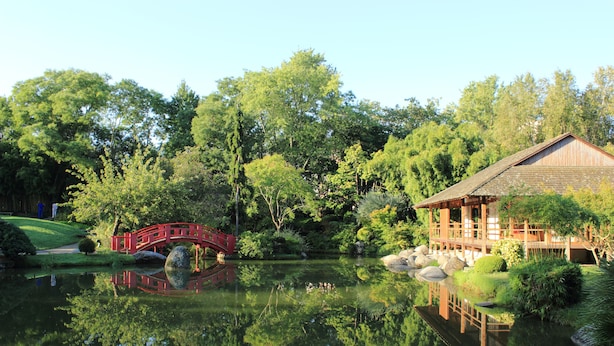 A traditional Japanese-style garden with a red bridge, a wooden house, and a pond. - Novotel Toulouse Centre Compans Caffarelli (Toulouse)