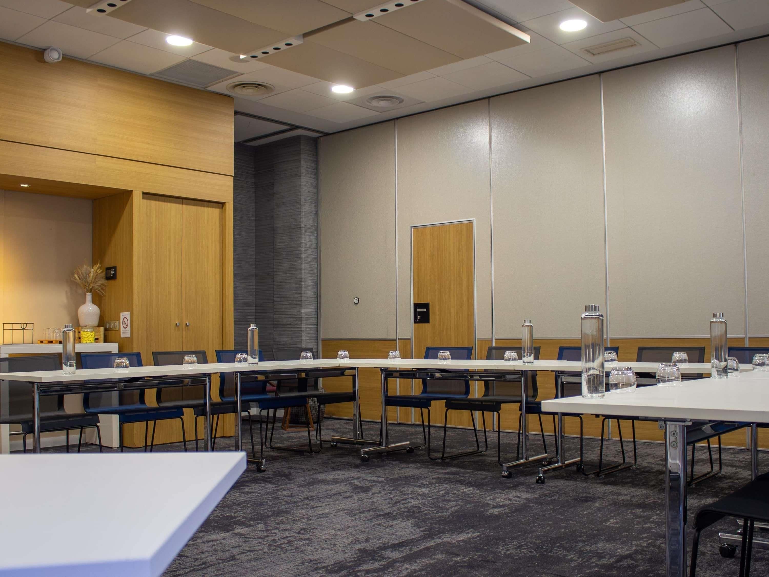 A conference room with a long table, chairs, and water bottles.