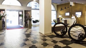 A hotel lobby with a reception desk, seating area, and a large arched doorway leading outside. - Novotel Toulouse Centre Compans Caffarelli (Toulouse)