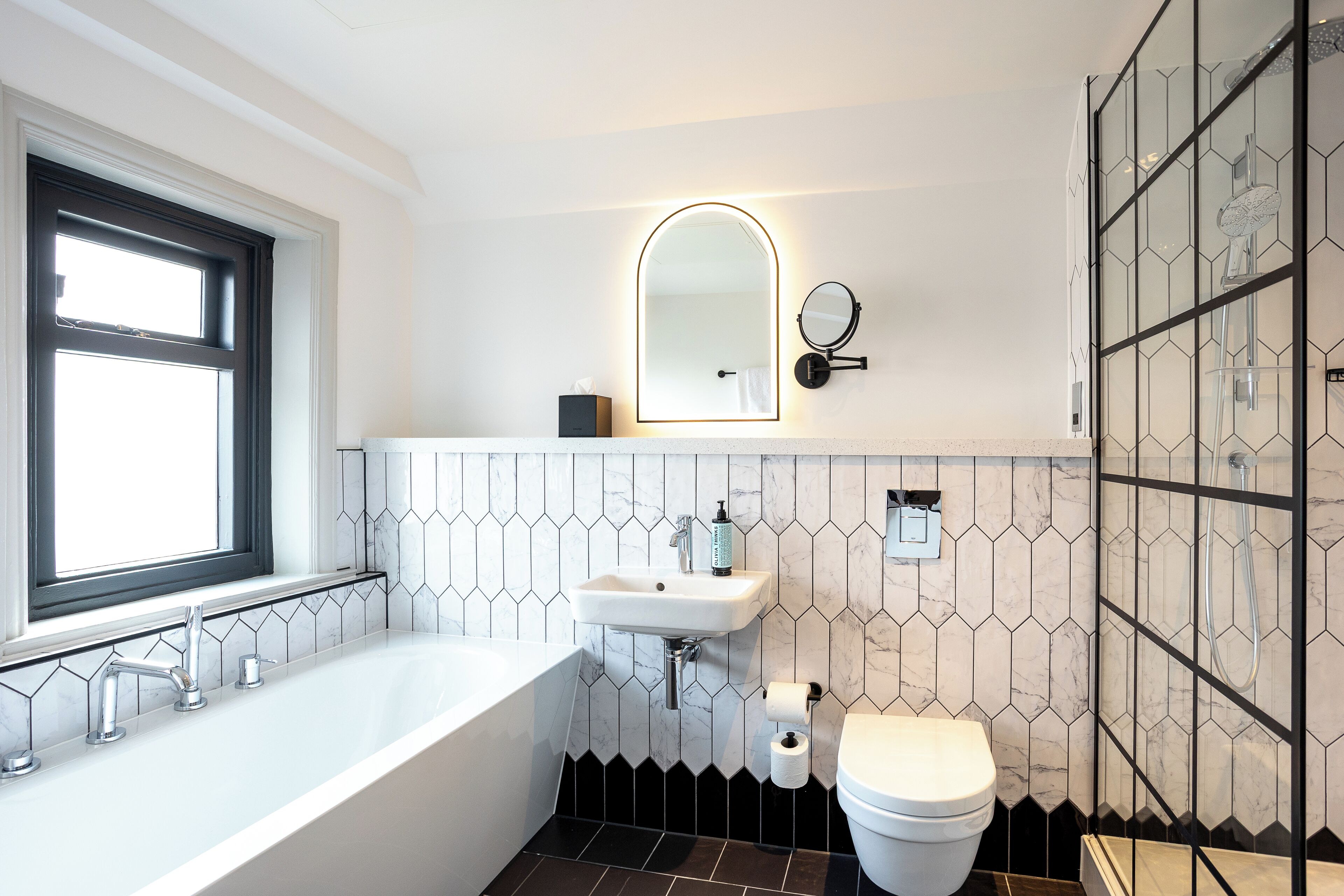 A modern bathroom with a freestanding bathtub, a toilet, and a sink.