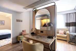 A modern hotel room with a bed, a desk with a chair, a sofa, a round table, and a large mirror. - The Met Hotel Leeds - Newly Refurbished (Leeds)
