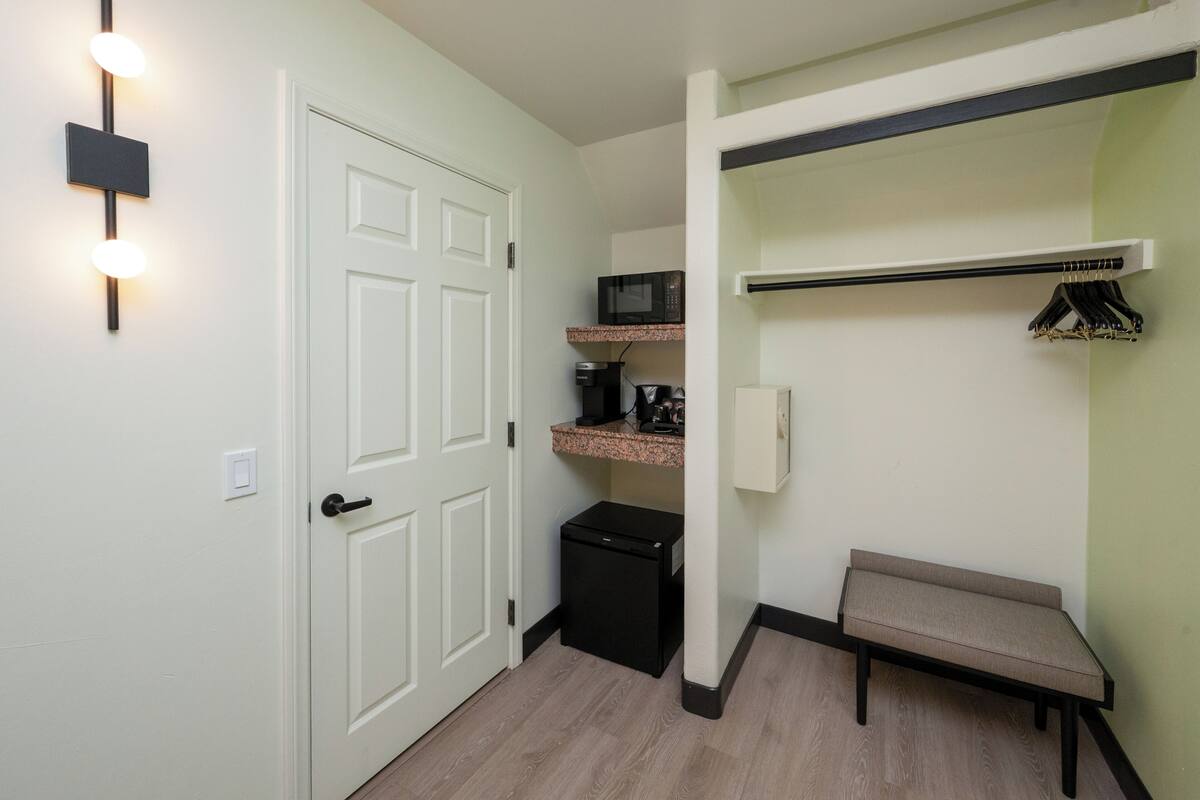 A compact kitchenette with a microwave, coffee maker, and small refrigerator.