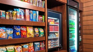 A snack and beverage display area with shelves of various snacks and a refrigerated section with drinks. - Fairfield Inn & Suites by Marriott Branson (Branson)