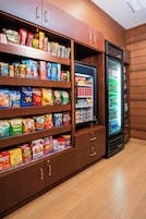 A snack and beverage display area with shelves of various snacks and a refrigerated section with drinks.